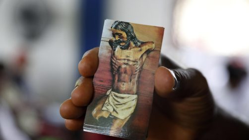 epa11315507 A man shows an image of the mutilated Christ of Bojayá during the commemoration of the 22nd anniversary of the Bojaya massacre, in Bojaya, Colombia, 02 May 2024. The Afro-descendant and indigenous communities of Bojaya, a municipality in the Colombian department of Choco, held a commemoration ceremony for the relatives and friends who died in the massacre that in which more than a hundred people were killed, 22 years ago.  EPA/Luis Eduardo Noriega A.